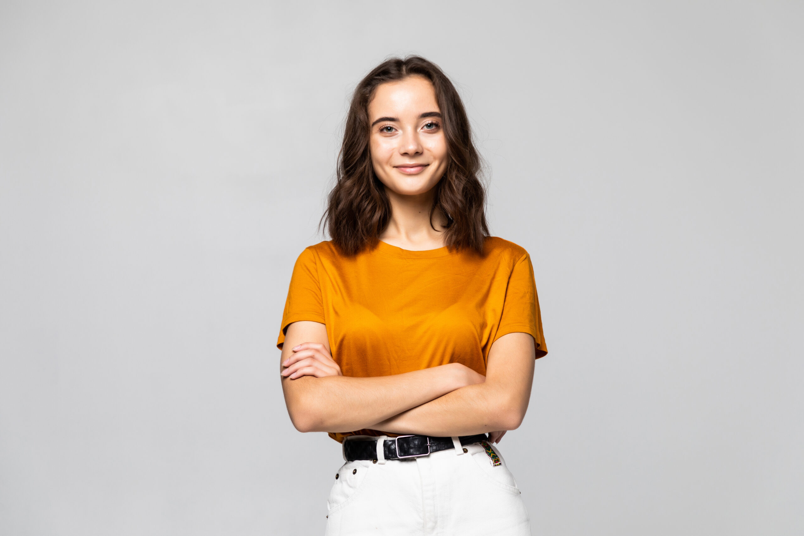 Young Woman arms crossed on grey background