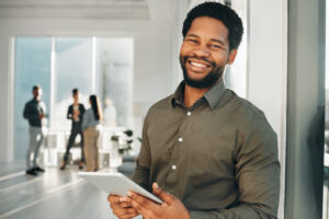 Smiling man holding tablet in an office