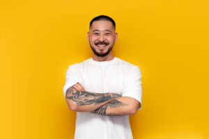 tatooed man in white shirt on orange background