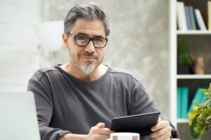 Man smirking holding tablet computer